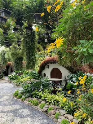 a garden with a dog house and flowers at LOVE LODGE BRINCHANG, CAMERON HIGHLANDS in Tanah Rata