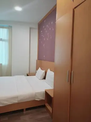 a bedroom with a large bed and a closet at Hills Aranda Nova Hotel in Cameron Highlands