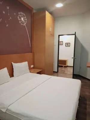 a bedroom with a bed with a dandelion painting on the wall at Hills Aranda Nova Hotel in Cameron Highlands
