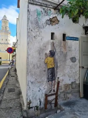 a mural of a boy on the side of a wall at Room at Lebuh Armenian Georgetown City Center in George Town