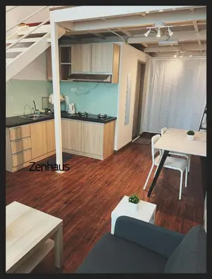 a living room with a table and a kitchen at The ceo suites by Zenbnb in Bayan Lepas