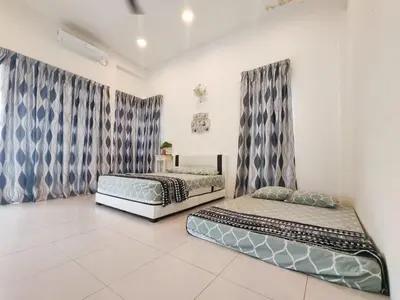 two beds sitting in a room with curtains at Teluk Batik 17ParadiseHome Private Pool Karaoke Snooker BBQ 15pax in Lumut