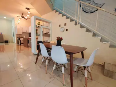 a dining room with a table and white chairs at Teluk Batik 17ParadiseHome Private Pool Karaoke Snooker BBQ 15pax in Lumut