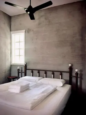 a bed with white sheets and a ceiling fan at 80 Colonie Fraser's Hill 8pax in Bukit Fraser