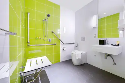 a bathroom with a sink and a toilet and green tiles at MU Hotel in Ipoh