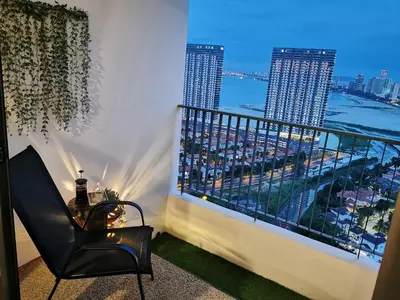 a balcony with a table and a view of a harbor at Landmark Lovely Coast View King Suite#500mbpsWifi#Netflix in Tanjong Tokong