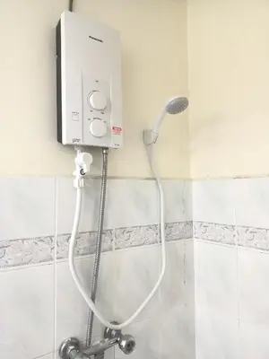 a shower with a white hose attached to a wall at Pangkor Coral Bay Resort(2 bedrooms) in Pangkor