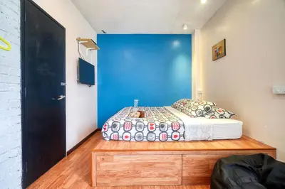 a bedroom with a bed and a blue door at Snooze TOO in Brinchang