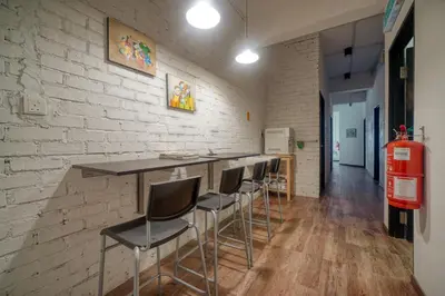 a bar with stools in a room with a brick wall at Snooze TOO in Brinchang