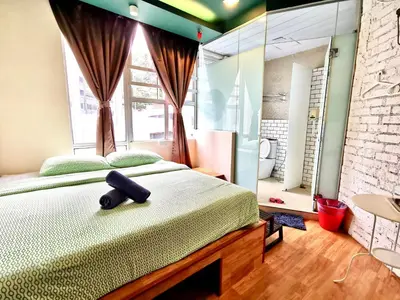 a bedroom with a large bed and a mirror at Snooze TOO in Brinchang