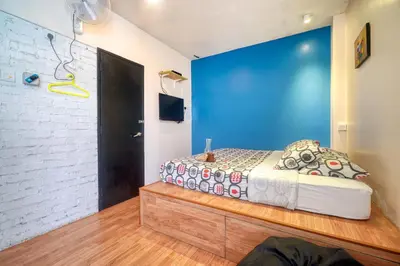 a bedroom with a bed and a blue wall at Snooze TOO in Brinchang