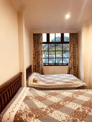 a bedroom with two beds in front of a window at Hotel Chua Gin @ Brinchang Centre in Brinchang
