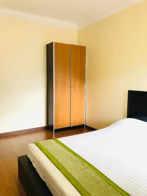 a bedroom with a large bed and a wooden cabinet at Hotel Chua Gin @ Brinchang Centre in Brinchang