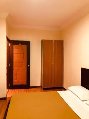 a bedroom with a bed and a closet and a door at Hotel Chua Gin @ Brinchang Centre in Brinchang