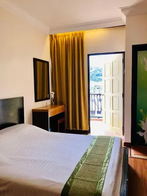 a bedroom with a bed and a desk and a window at Hotel Chua Gin @ Brinchang Centre in Brinchang