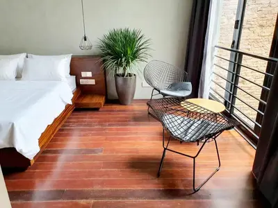 a bedroom with a bed and a chair and a table at Luxurious 7 BR Heritage House in UNESCO Historic Geogetown in George Town