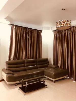 a living room with a leather couch and curtains at Crown Imperial Court Apt at Brinchang Centre in Brinchang