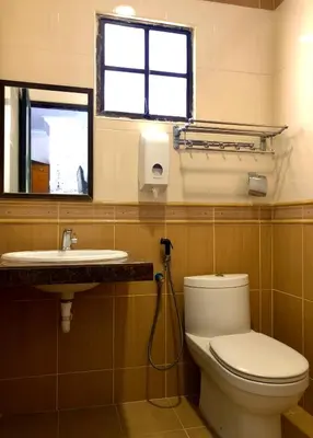 a bathroom with a toilet and a sink and a window at Crown Imperial Court Apt at Brinchang Centre in Brinchang