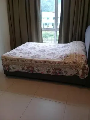 a bed sitting in a room with a window at Crown Imperial Court Apt at Brinchang Centre in Brinchang