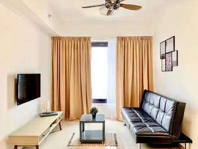 a living room with a leather couch and a table at Georgetown Tropicana 218 Apartment in George Town