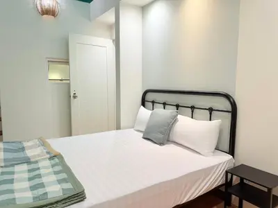 a small bedroom with a bed with white sheets at Ocean 19 Shamrock Villa Beachfront Big Group 4 Bedroom 5 Bathroom with Pool in Tanjung Bungah