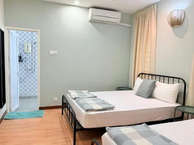 a bedroom with two beds and a door to a bathroom at Ocean 19 Shamrock Villa Beachfront Big Group 4 Bedroom 5 Bathroom with Pool in Tanjung Bungah