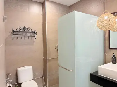 a bathroom with a shower and a toilet and a sink at Ocean 19 Shamrock Villa Beachfront Big Group 4 Bedroom 5 Bathroom with Pool in Tanjung Bungah