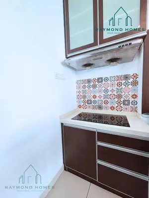 a kitchen with a stove and a tile wall at Gurney Drive Mansion One Serviced Apartment in George Town