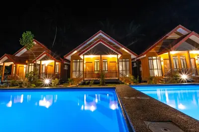 a house with a swimming pool at night at Cinta Abadi Resort in Bidur