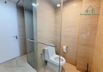 a bathroom with a toilet with a glass door at Beachfront Resort By The Sea, Batu Ferringhi in Batu Ferringhi
