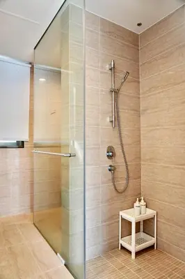 a shower stall with a glass door in a bathroom at Beachfront Resort By The Sea, Batu Ferringhi in Batu Ferringhi