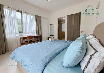 a bedroom with a bed with a blue comforter at Beachfront Resort By The Sea, Batu Ferringhi in Batu Ferringhi