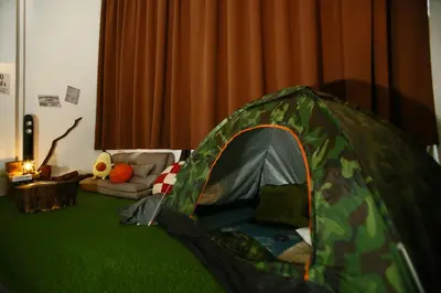 a green tent in a living room with a couch at Private Forest Camp - Cinema, Hammock, Swing at CEO Penang in Bayan Lepas