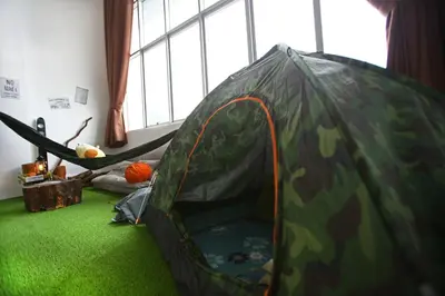 a green tent with a hammock in a room at Private Forest Camp - Cinema, Hammock, Swing at CEO Penang in Bayan Lepas