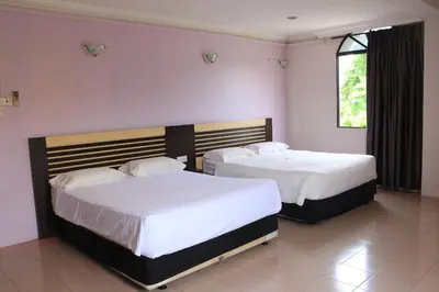 two beds in a bedroom with pink walls at Hotel Lam Seng in Pantai Remis