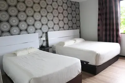 a bedroom with two beds and a wall with a mural at Hotel Lam Seng in Pantai Remis