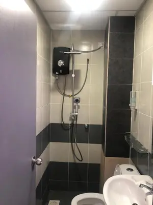a bathroom with a shower and a toilet and a sink at Ramadhina Eagle Eye View Home2stay Emerald Avenue in Brinchang