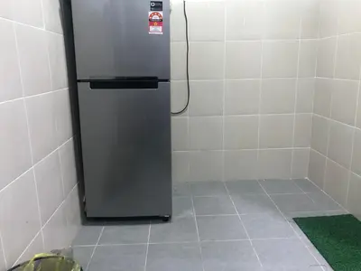 a stainless steel refrigerator in a corner of a room at Ramadhina Eagle Eye View Home2stay Emerald Avenue in Brinchang