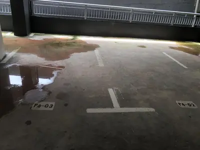 a parking lot with a puddle of water on the ground at Ramadhina Eagle Eye View Home2stay Emerald Avenue in Brinchang