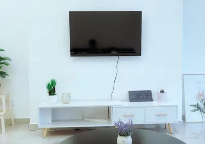a white desk with a television on a wall at \u805a\u4e50\u5c4b\u6c11\u5bbfJyuraku homestay The venus sitiawan in Sitiawan