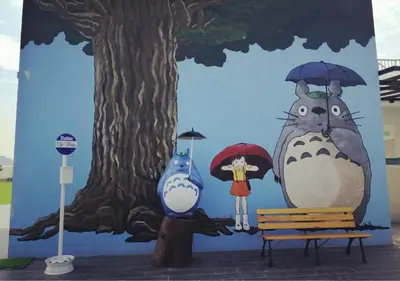 a wall with a painting of a cat and a woman with umbrellas at \u805a\u4e50\u5c4b\u6c11\u5bbfJyuraku homestay The venus sitiawan in Sitiawan
