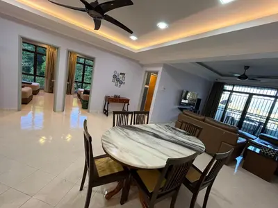 a dining room and living room with a table and chairs at EagleNest at Marina Cove Resort in Lumut