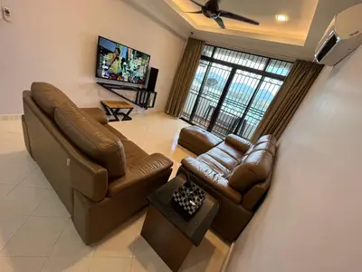 a living room with couches and a flat screen tv at EagleNest at Marina Cove Resort in Lumut