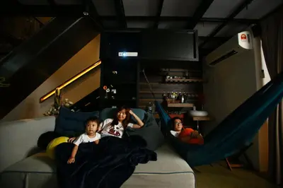 two children laying on a couch in a room at Private Getaway (Private Cinema, Swing & more!) at CEO Penang in Bayan Lepas