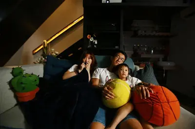two girls and a woman sitting on a couch at Private Getaway (Private Cinema, Swing & more!) at CEO Penang in Bayan Lepas