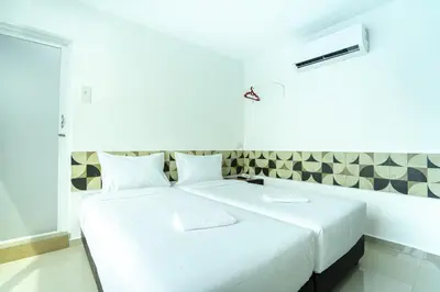 a white bedroom with a large white bed at Grand Bagan Hotel in Butterworth