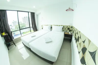 a large white bed in a room with a window at Grand Bagan Hotel in Butterworth
