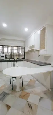 a white kitchen with a white table and a counter at Cozy Corner House #4 Bedroom #3 Bathroom in Ipoh