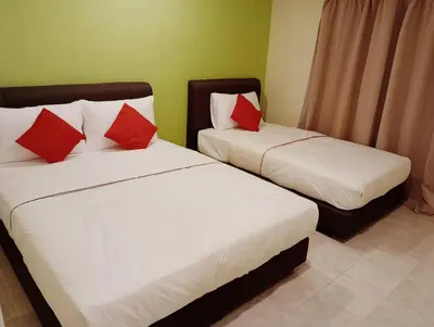 two beds with red pillows in a room at HOTEL SAHARA INN TANJUNG MALIM in Kampong Chabang