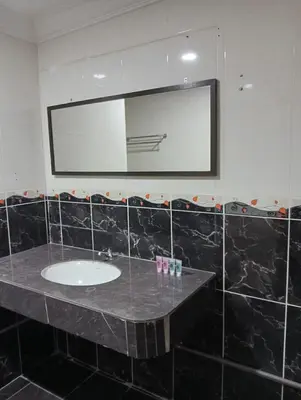a bathroom with a sink and a mirror at HOTEL SAHARA INN TANJUNG MALIM in Kampong Chabang